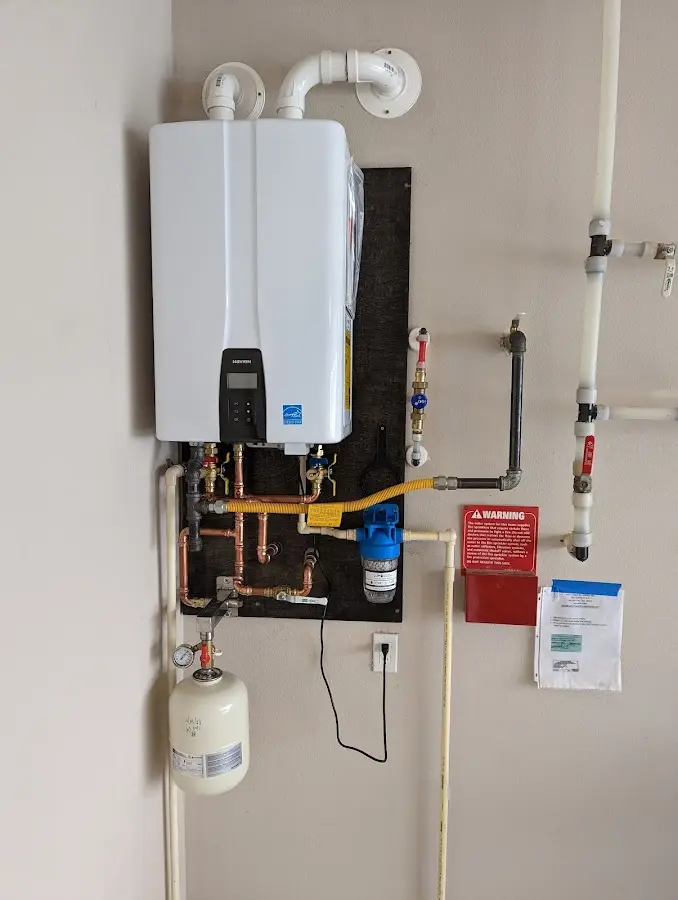 Professional plumber installing copper piping in a West Springfield Town home